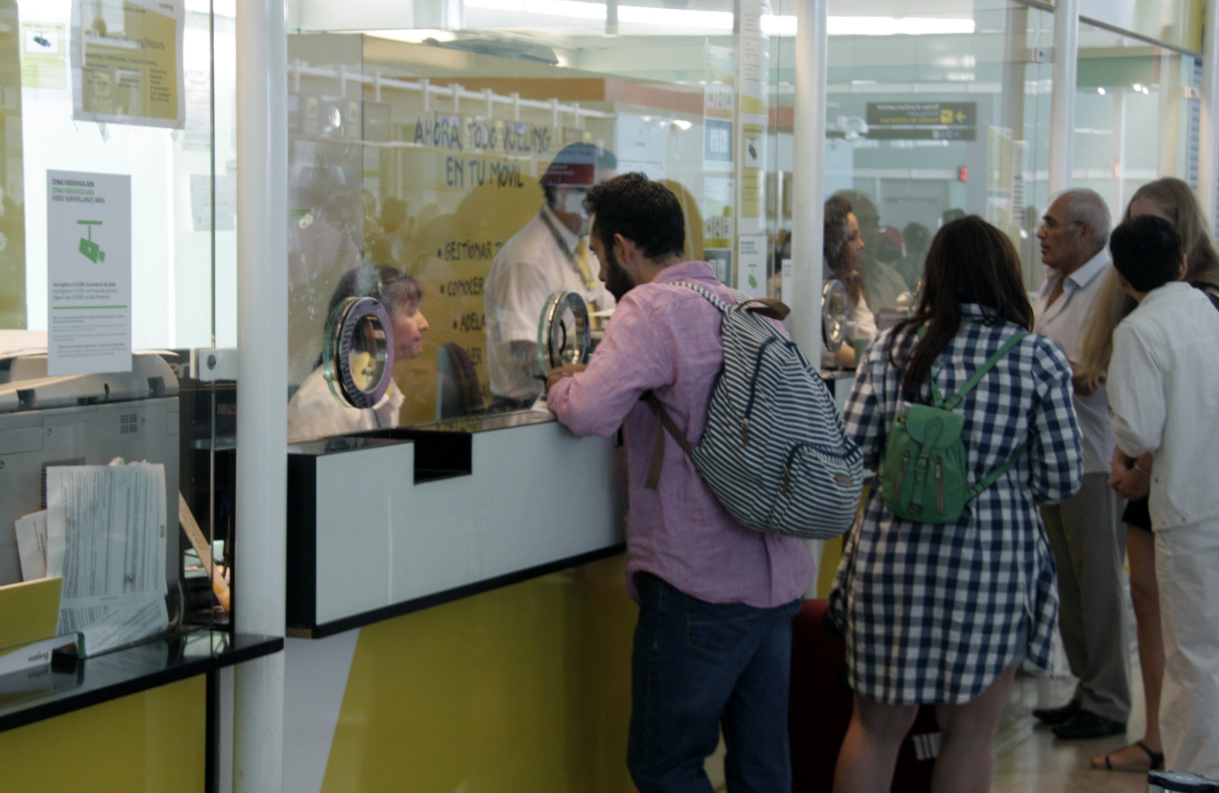 Un passatger als taulells d'atenció al cient de Vueling a l'aeroport del Prat aquest dilluns 