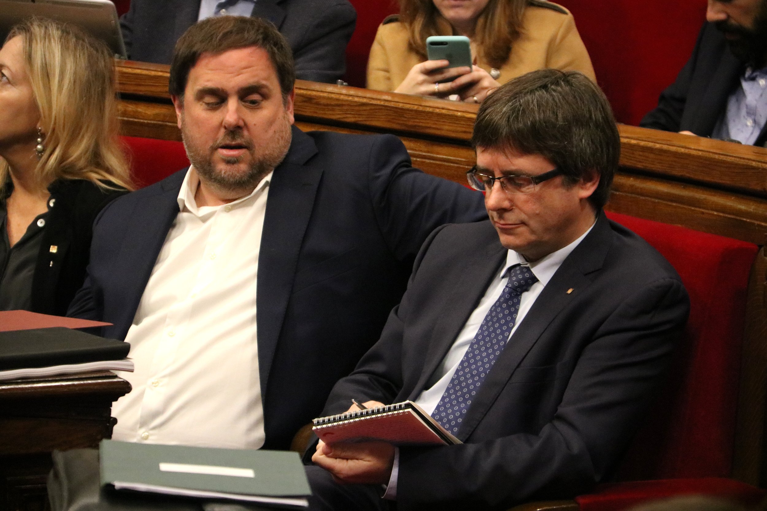 El president de la Generalitat, Carles Puigdemont, pren nota sota la mirada del vicepresident Oriol Junqueras