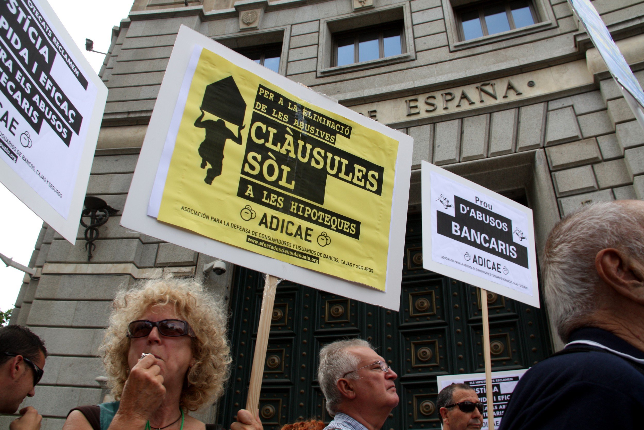 Una dona amb una pancarta en contra les clàusules sòl davant la seu del Banc d'Espanya