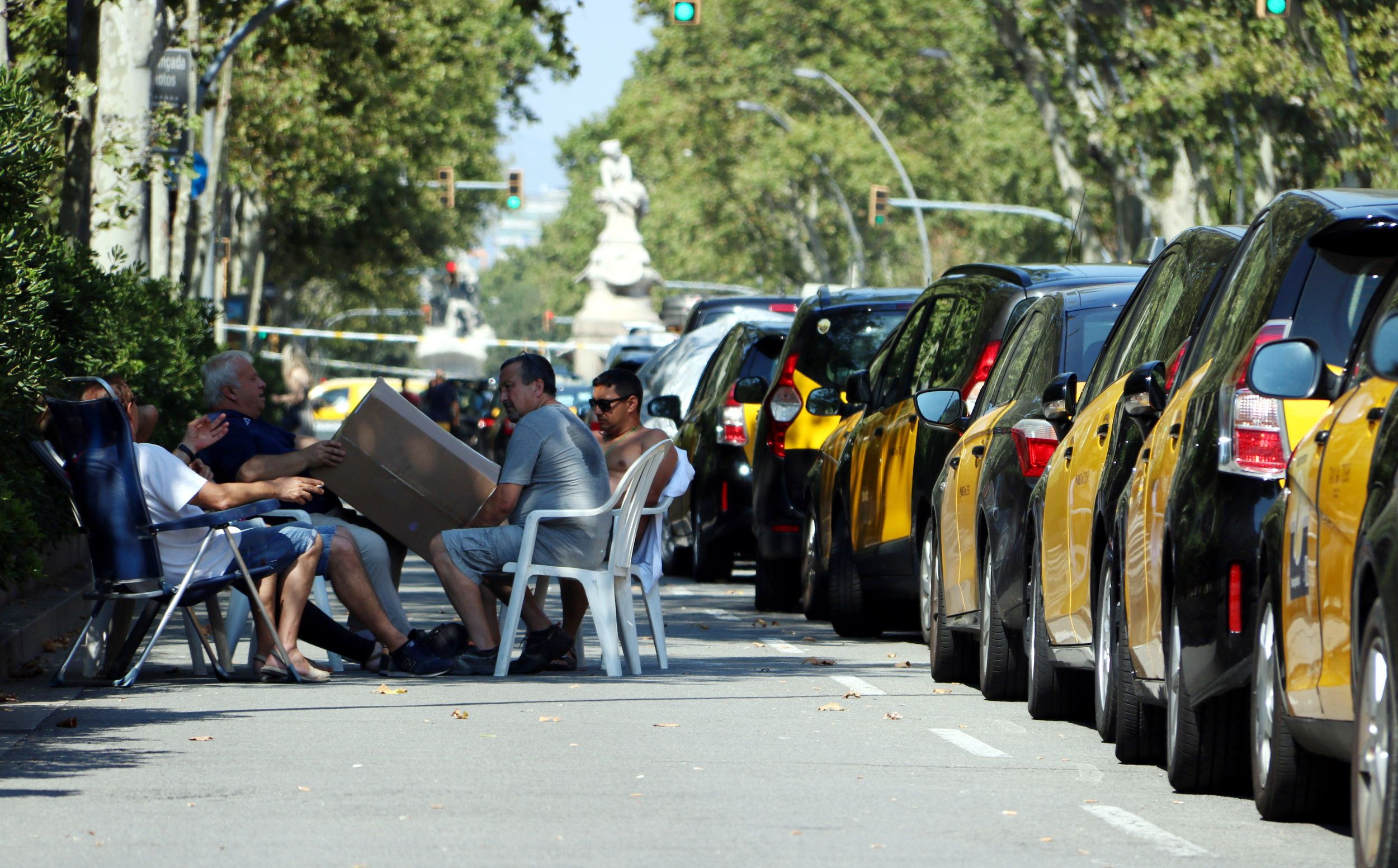 Un grup de taxistes en vaga, asseguts amb cadires i taules a la Gran Via | ACN