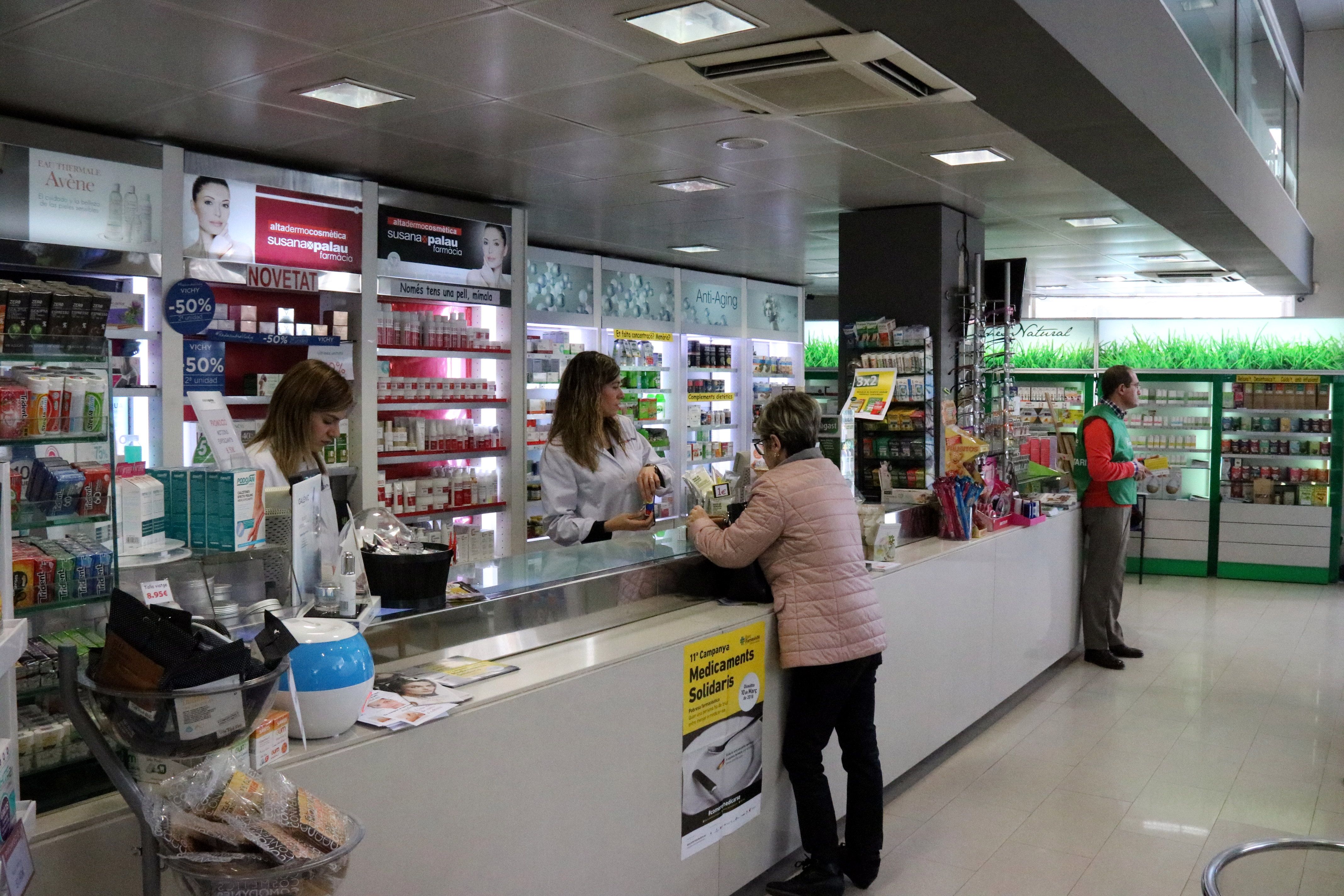 Una senyora compra en una farmàcia de Girona