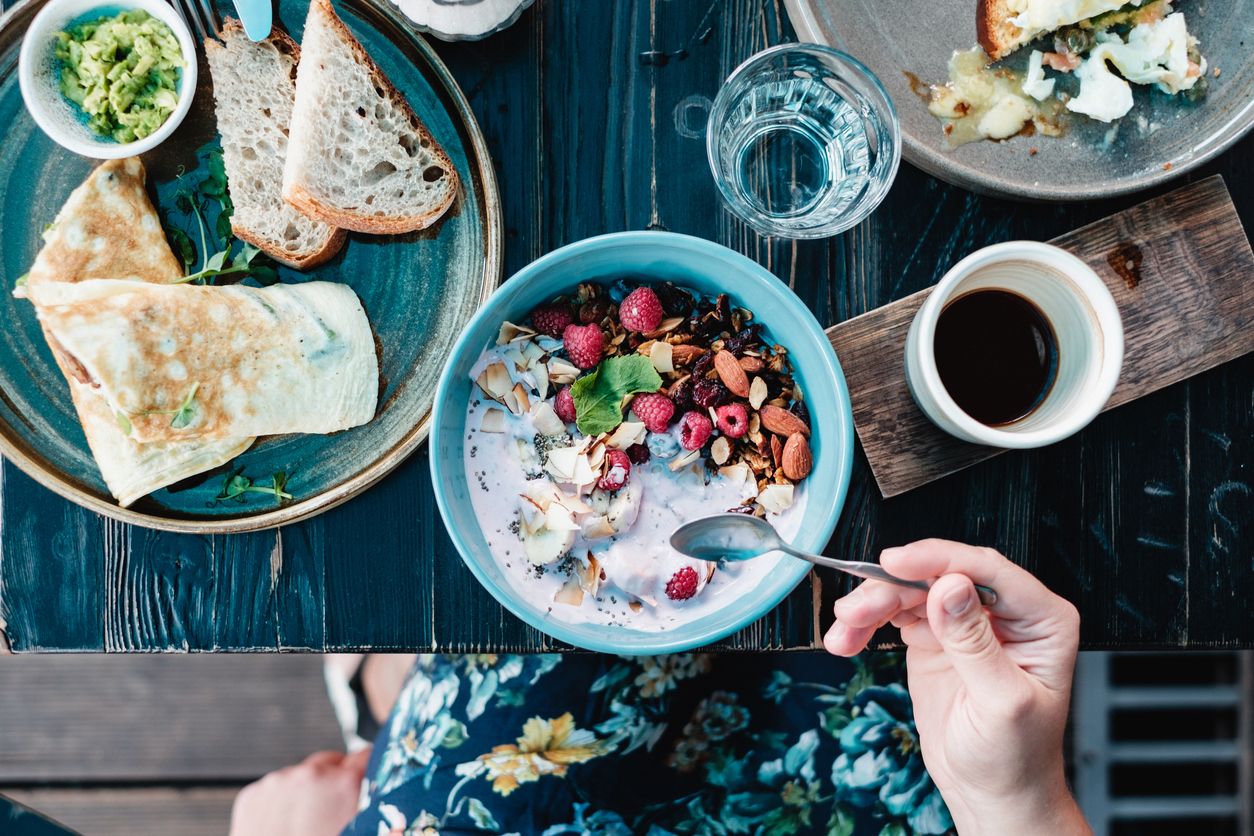 Una mujer comer yogurt natural cono granola y frutas frescas