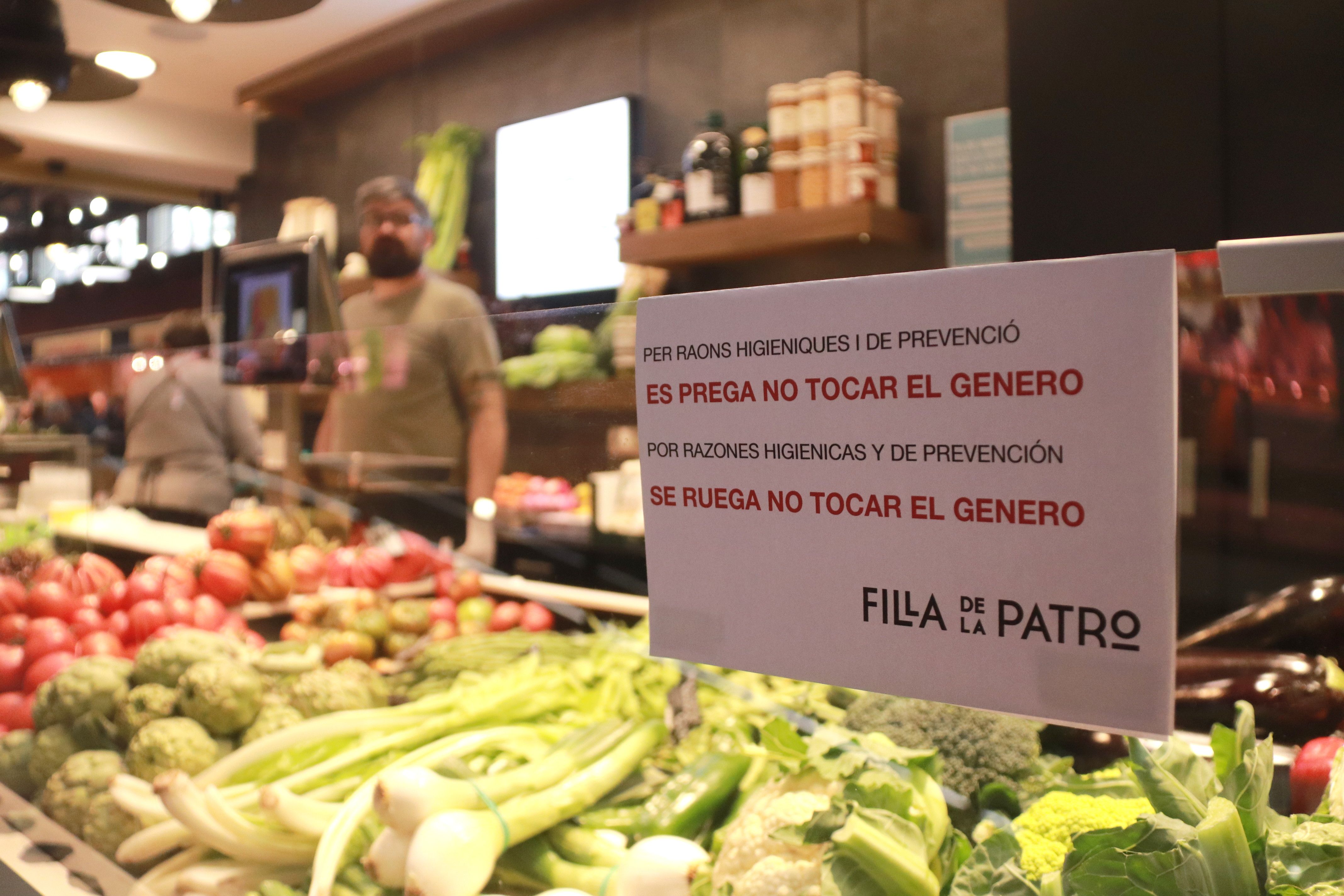 Cartell en una fruiteria del Mercat Central de Tarragona enganxat en una mampara per evitar que els clients toquin els productes | ACN (E. Tost)