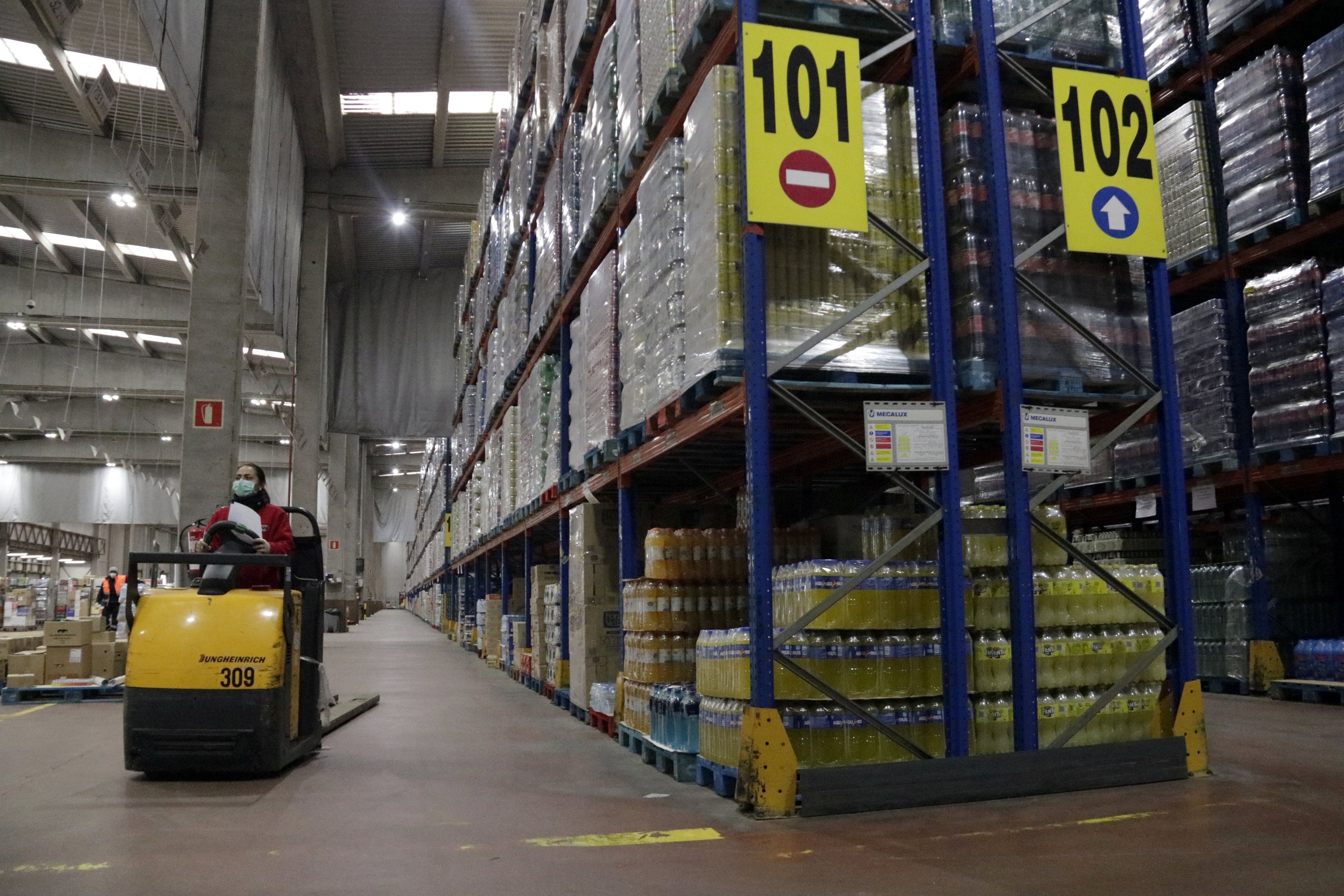 Trabajadores con mascareta preparando pedidos para supermercados y tiendas a GM Food a Vilamalla | ACN