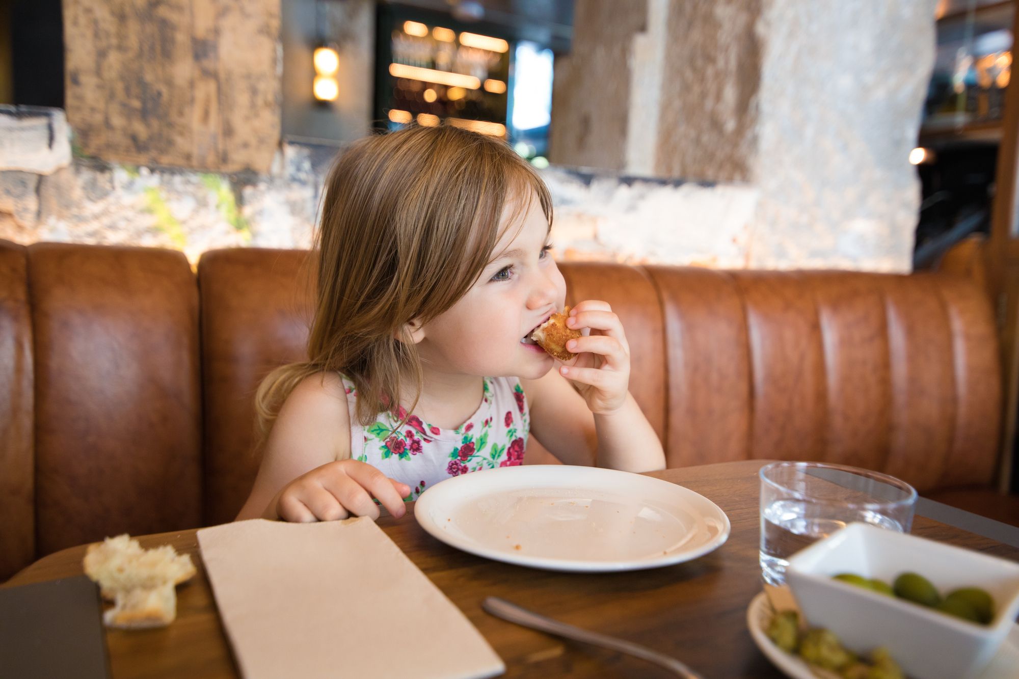 Imatge d'arxiu d'una nena menjant en un restaurant | iStock 