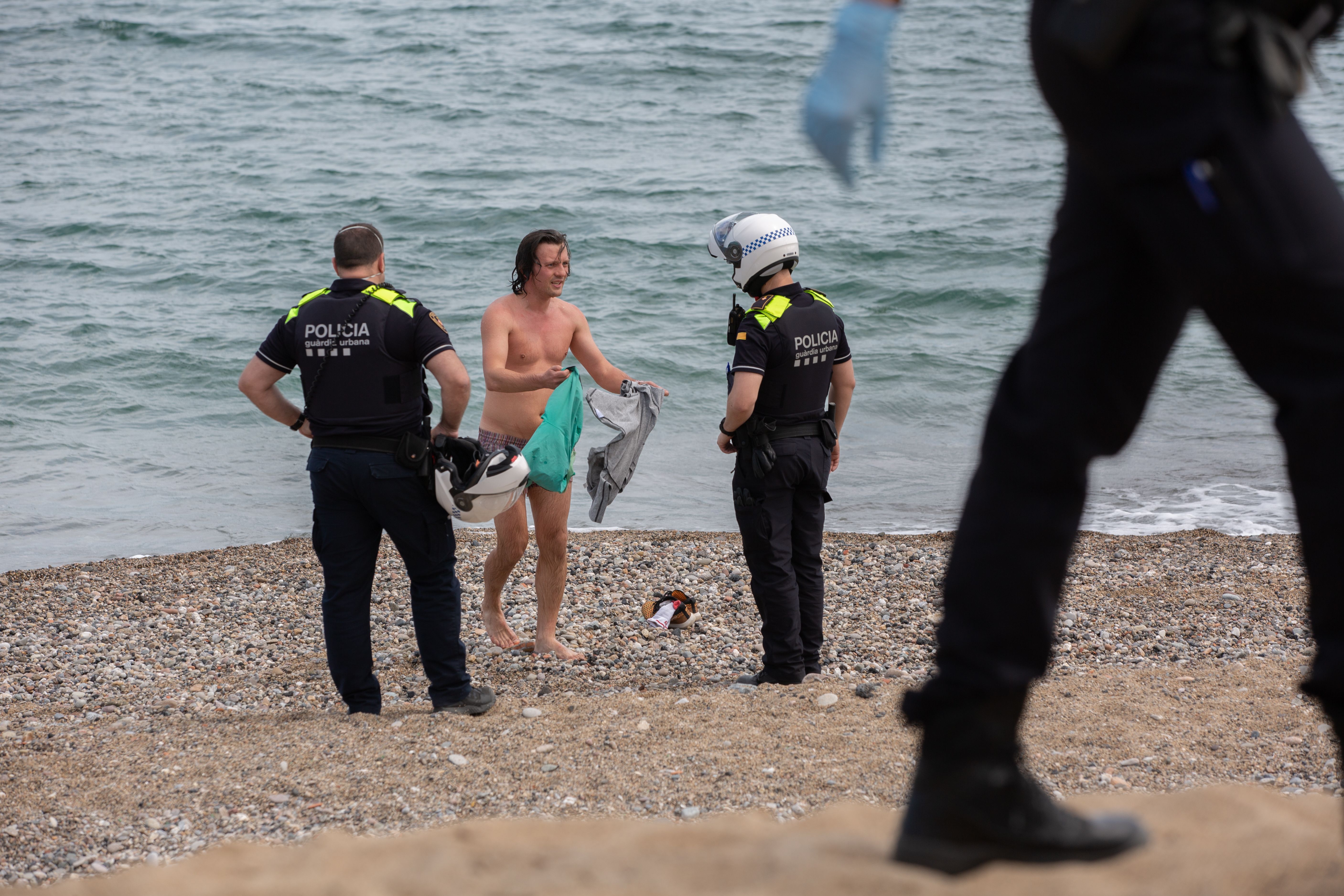 La Guàrdia Urbana con un bañista en la Playa Barcelona. | EP