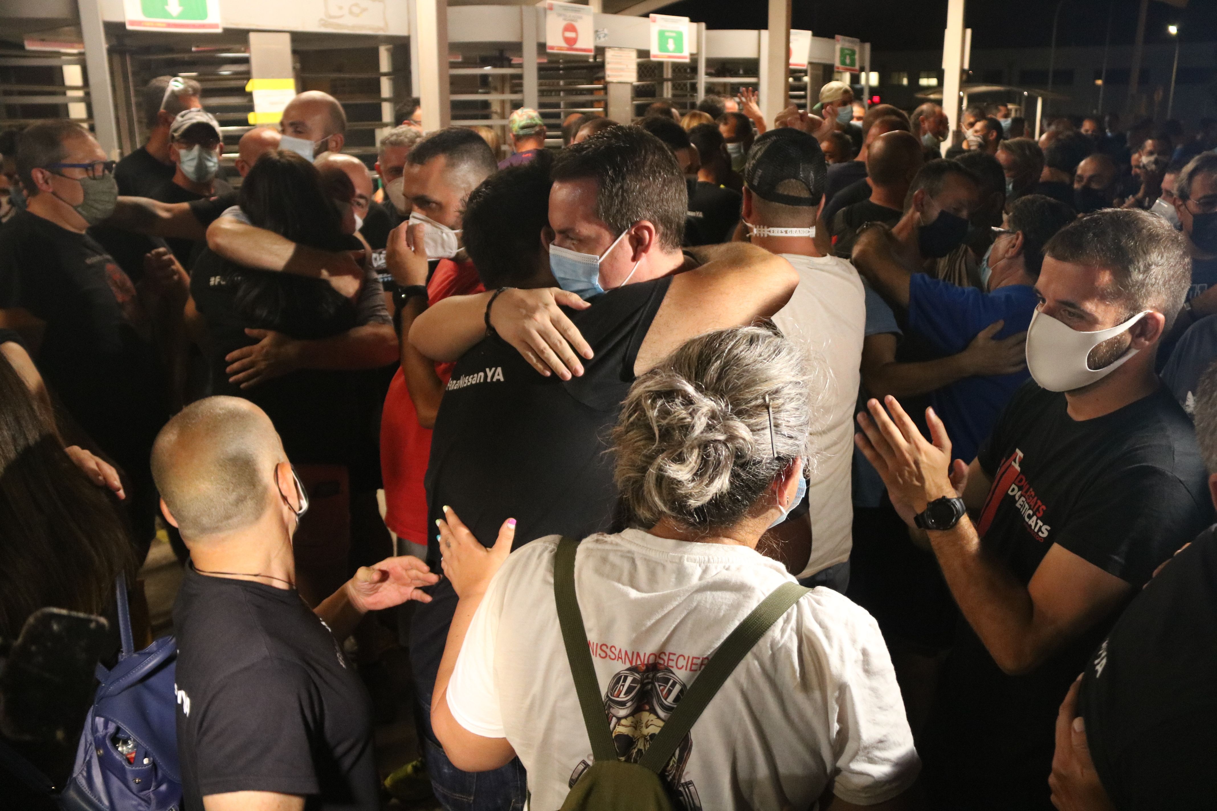 Dos trabajadores de Nissan abrazándose a la Zona franca después de que los sindicatos y la empresa hayan llegado a un acuerdo | ACN