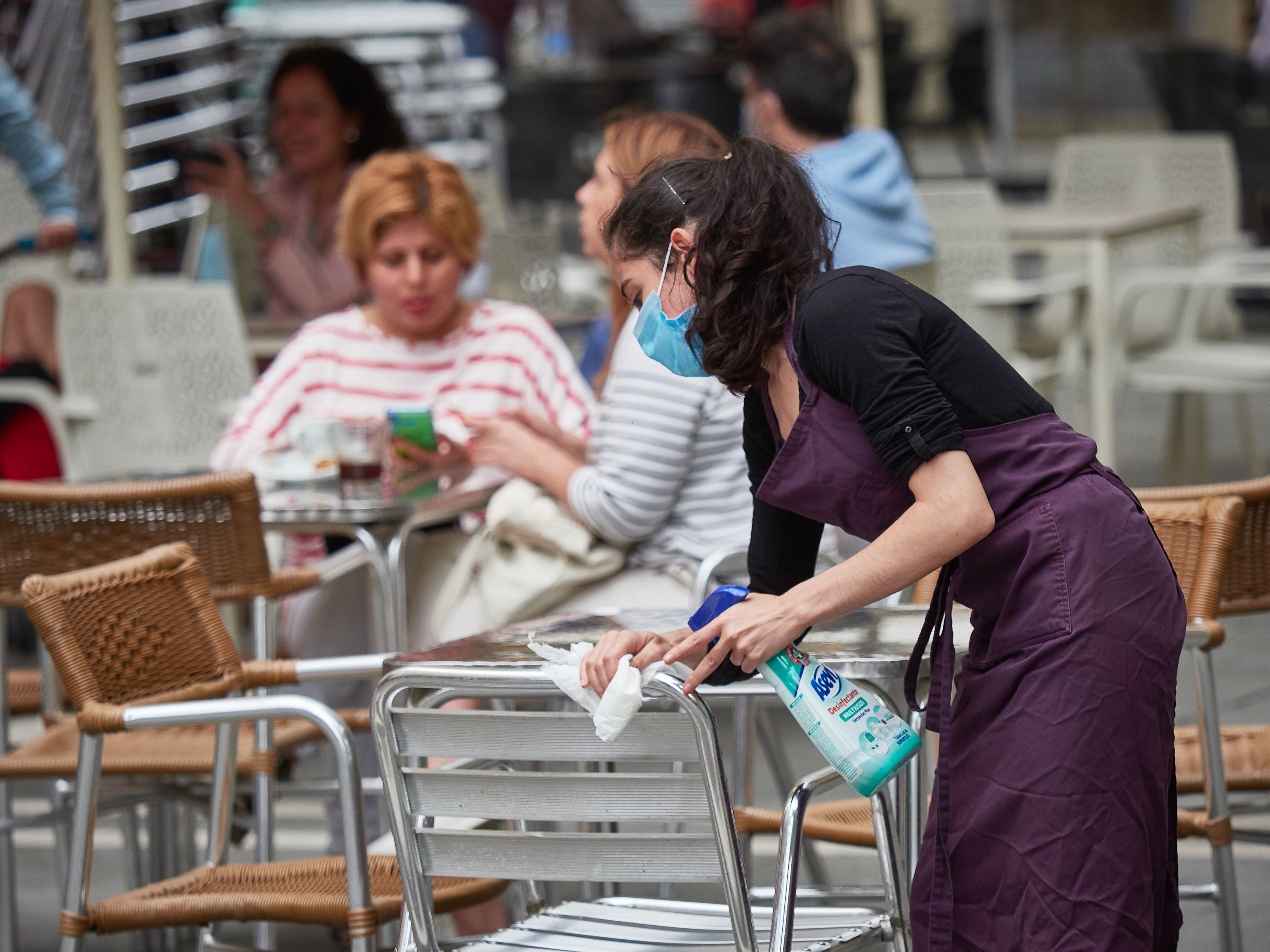 Una treballadora desinfecta una taula d'un restaurant | Europa Press