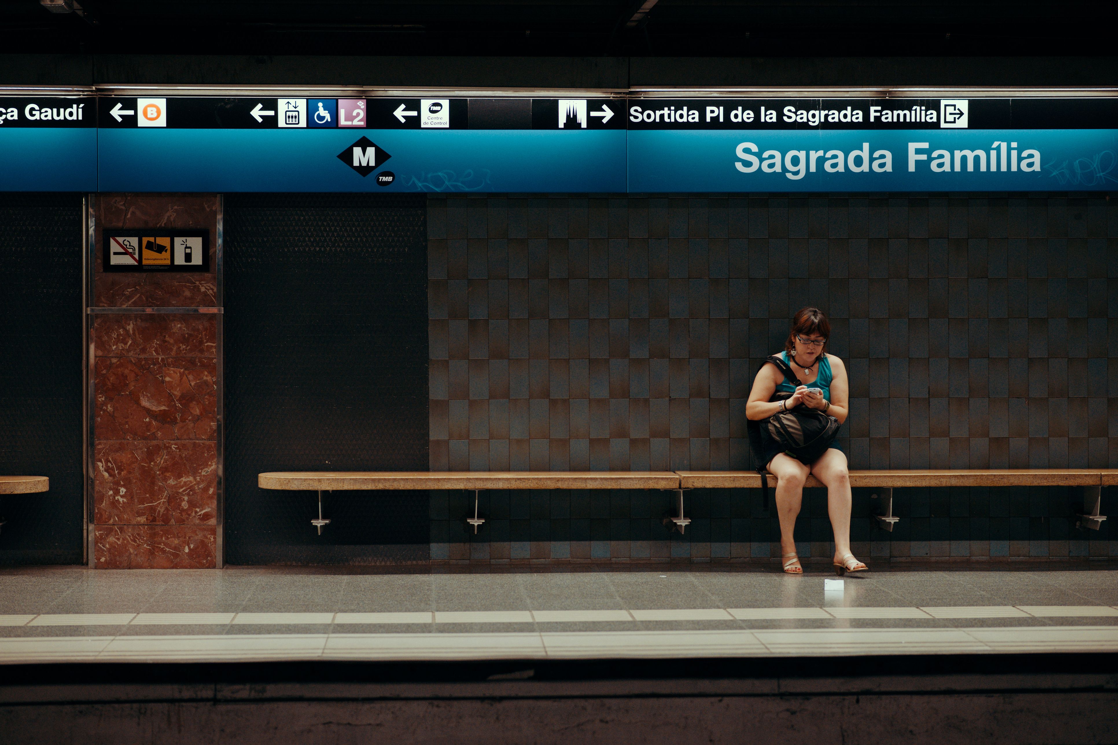 Una mujer esperando en la parada de metro de Sagrada Familia de Barcelona | iStock