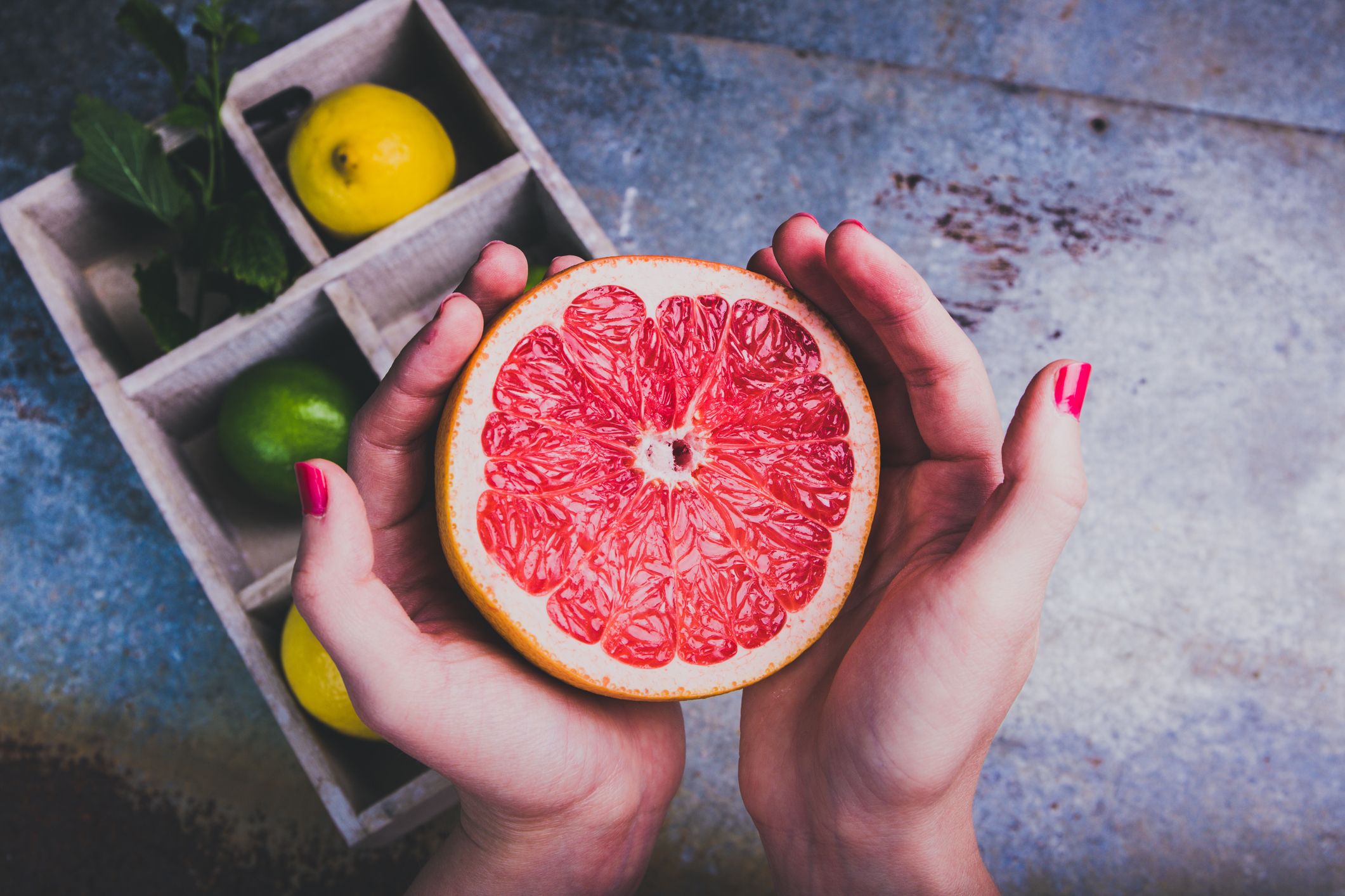 Una mujer cogiendo una naranja. | iStock