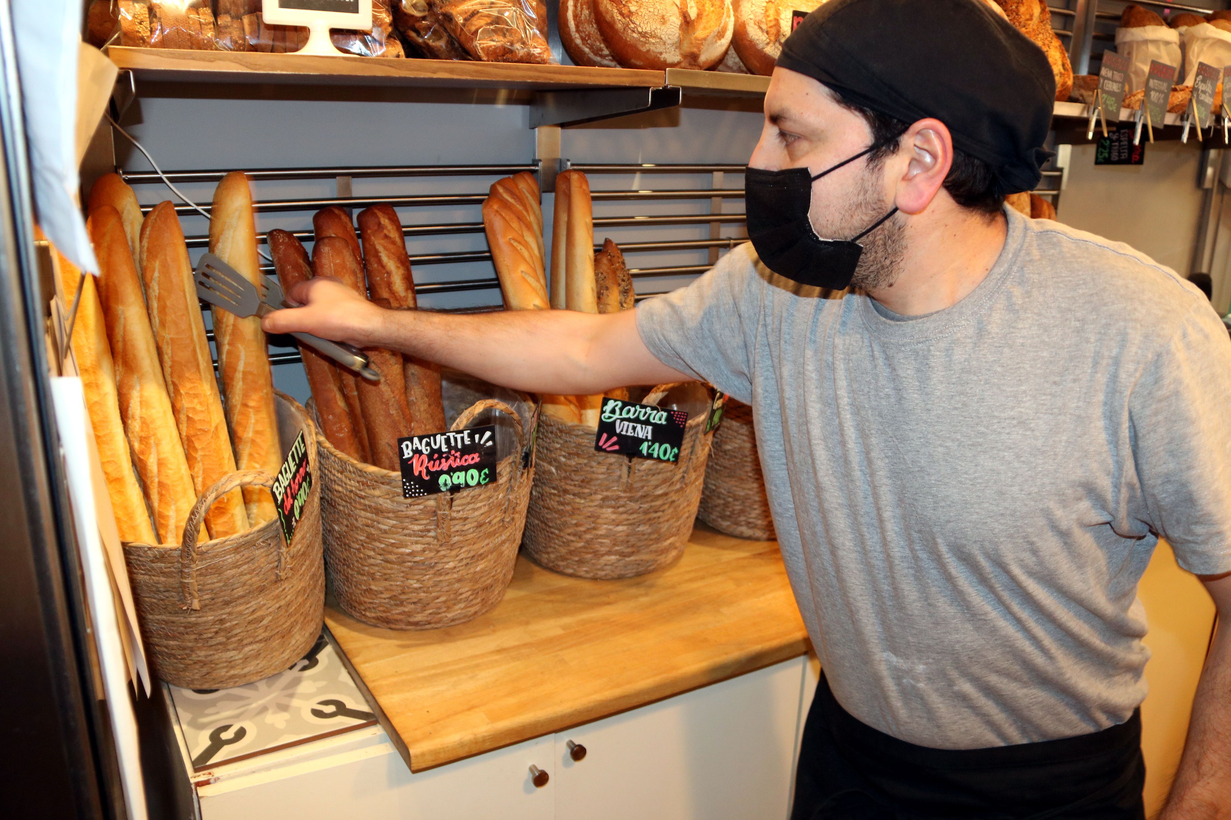 Un dependent agafa una barra de pa al forn de 'La Rovira' | ACN