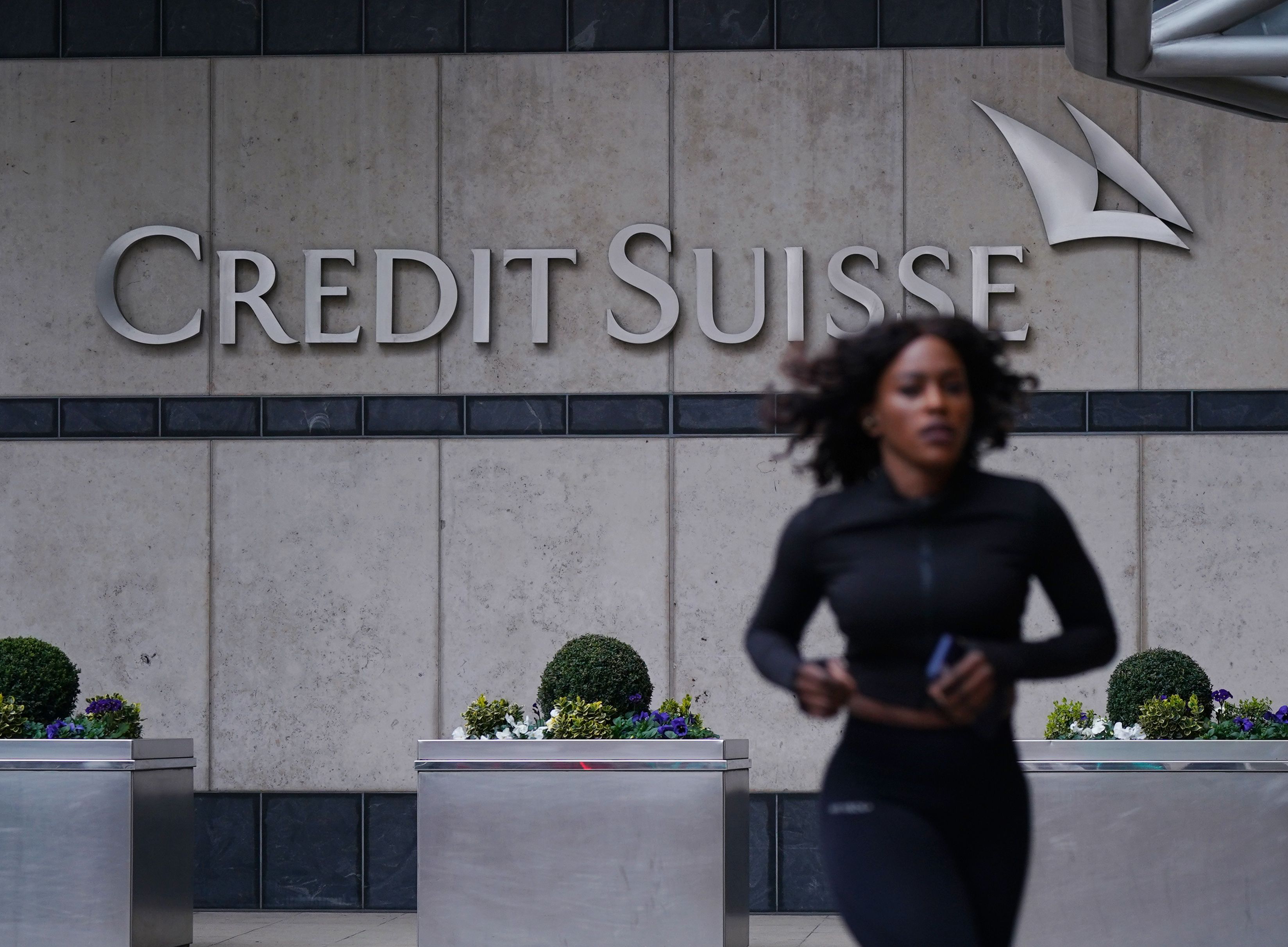 Una mujer pasa corriendo por delante de una oficina de Credit Suisse en Canary Wharf, el complejo de negocios de Londres | Yui Mok | Pan Wire | Dpa | Europa Press