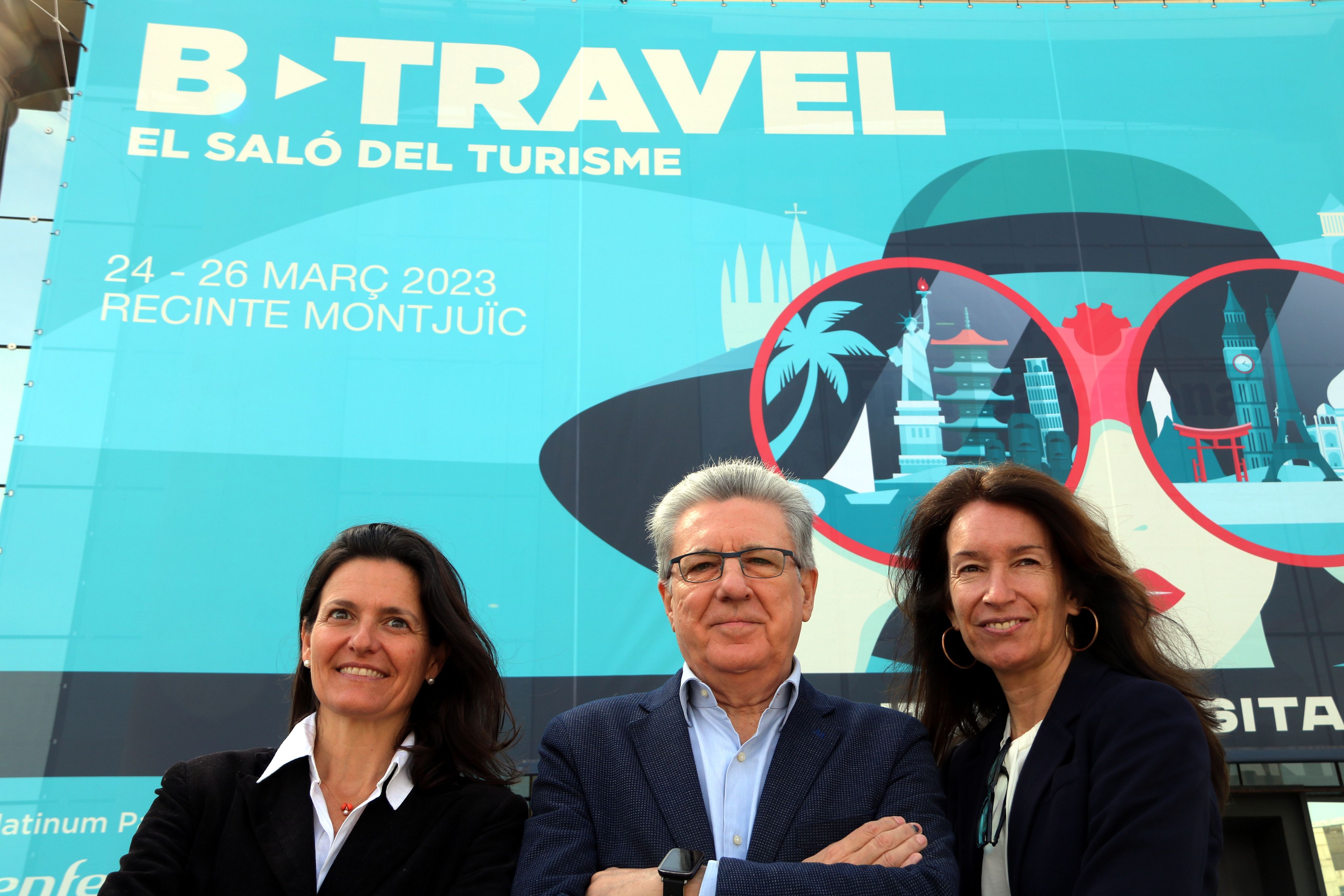 Marta Domènech, Martí Sarrate y Marta Serra ante el cartel del B-Travel en Fira Montjuïc | ACN