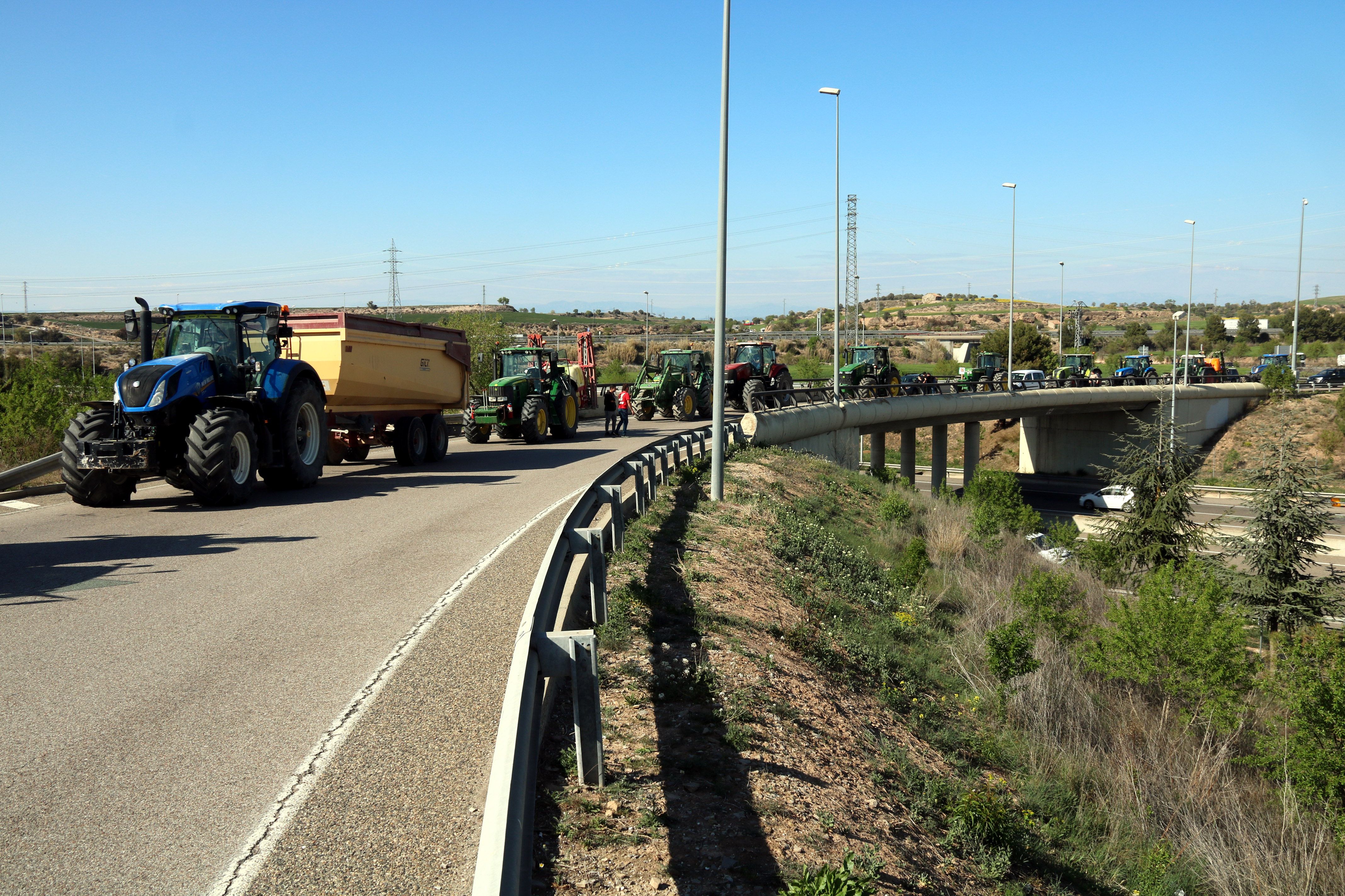 Tractors aturats a la rotonda d'accés a l'A-2 de Cervera mentre sota el pont es veu l'autovia | ACN