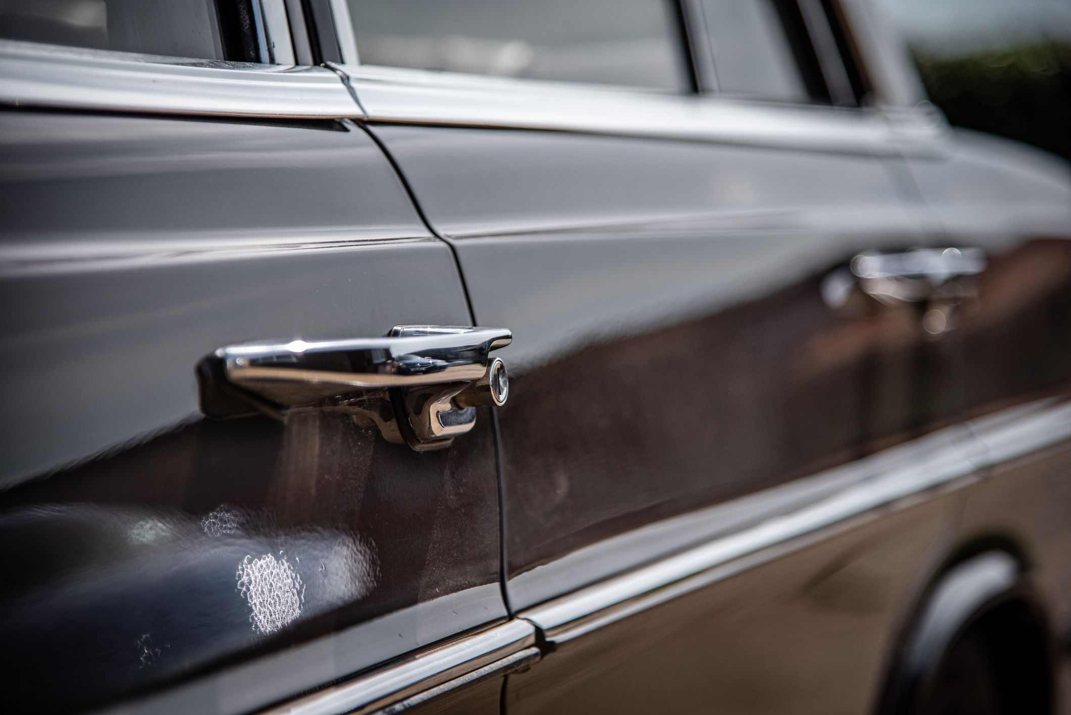 Manija de la puerta y un coche clásico de la época de los años 60 | iStock