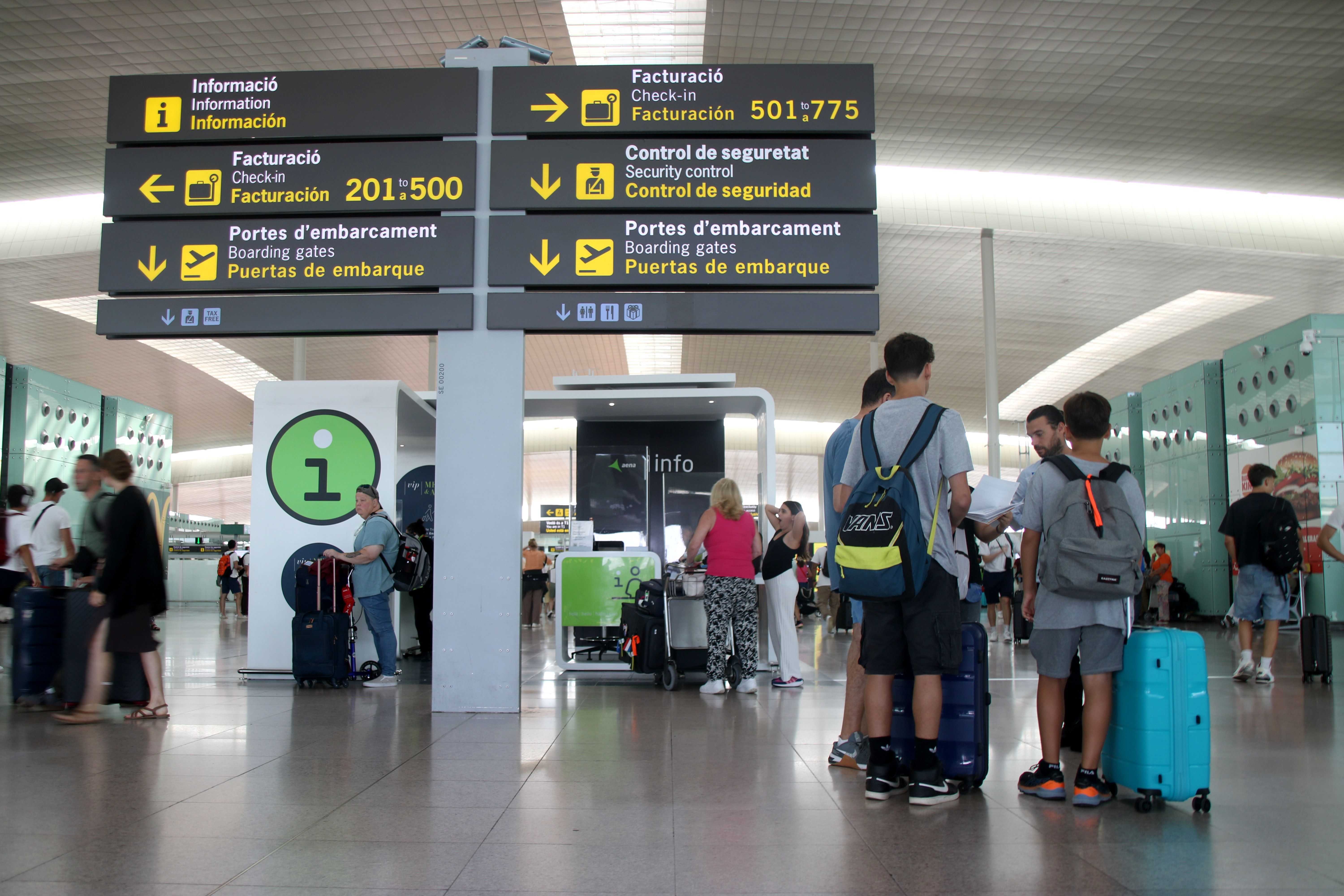 La terminal 1 de l'aeroport de El Prat amb una continu de gent desfilant | ACN