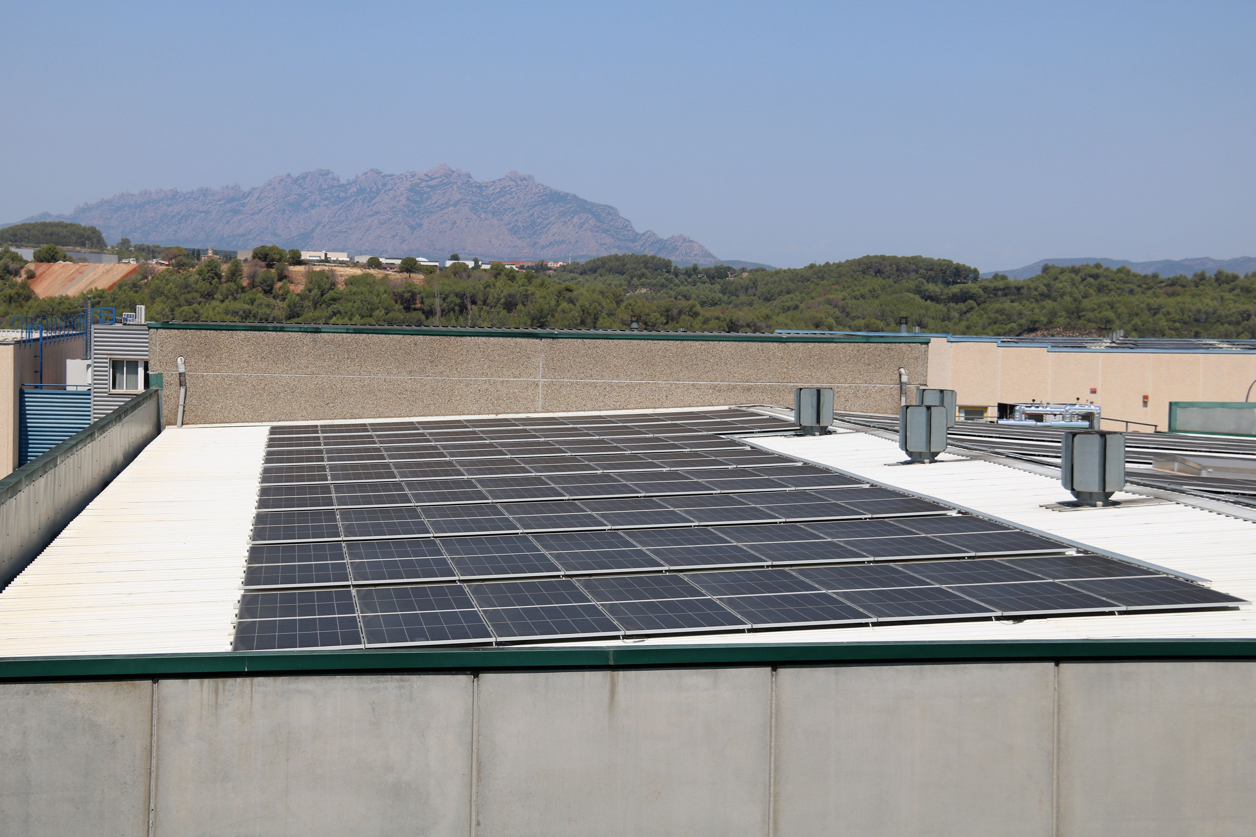 Visió general d'una instal·lació de la comunitat energètica del polígon industrial Rosanes, amb Montserrat al fons | ACN