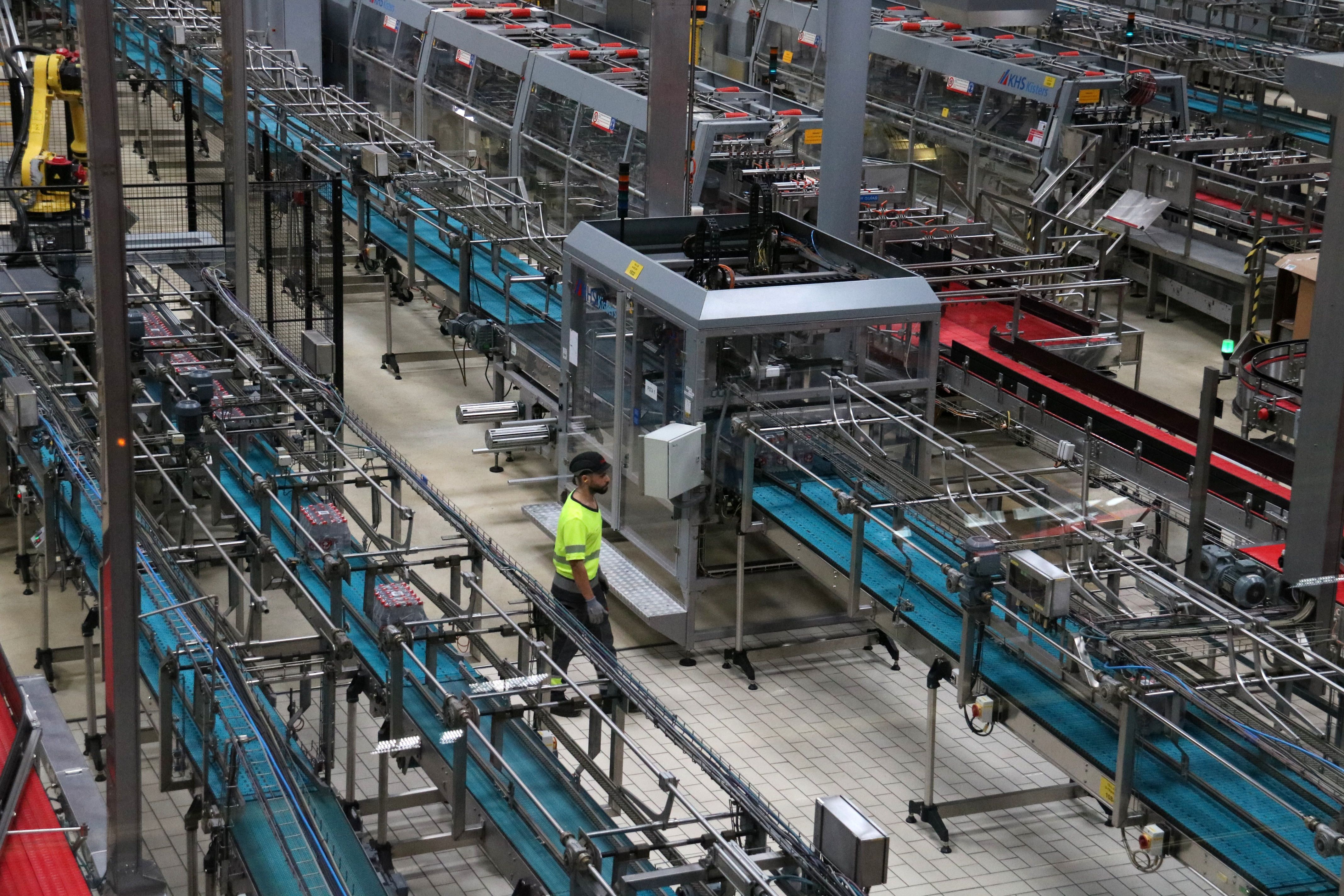 Treballador de Coca-Cola entre la maquinària de la fàbrica de Martorelles | ACN