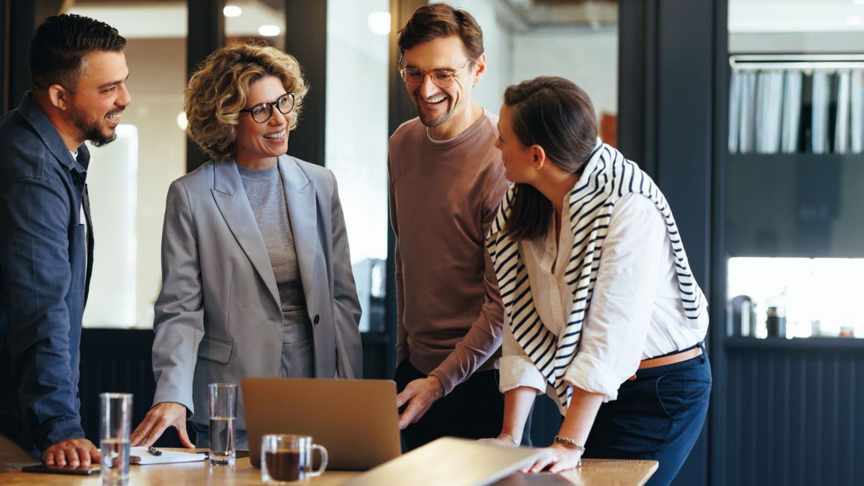 Trabajadores felices en su oficina | iStock