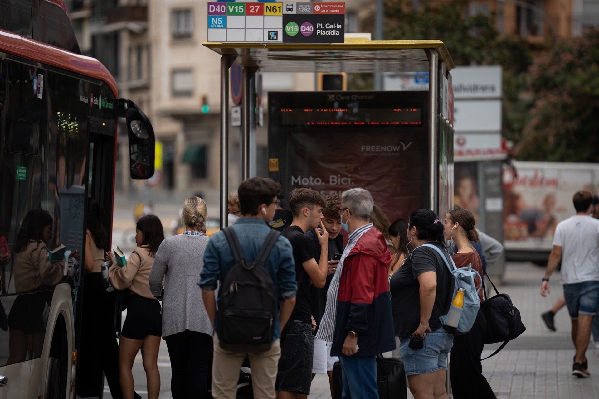 Varias personas esperan en la parada del autobús en Barcelona | EP