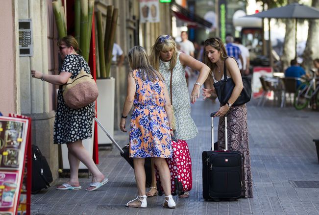 Un grup de turistes entrant en un pis turístic | EP