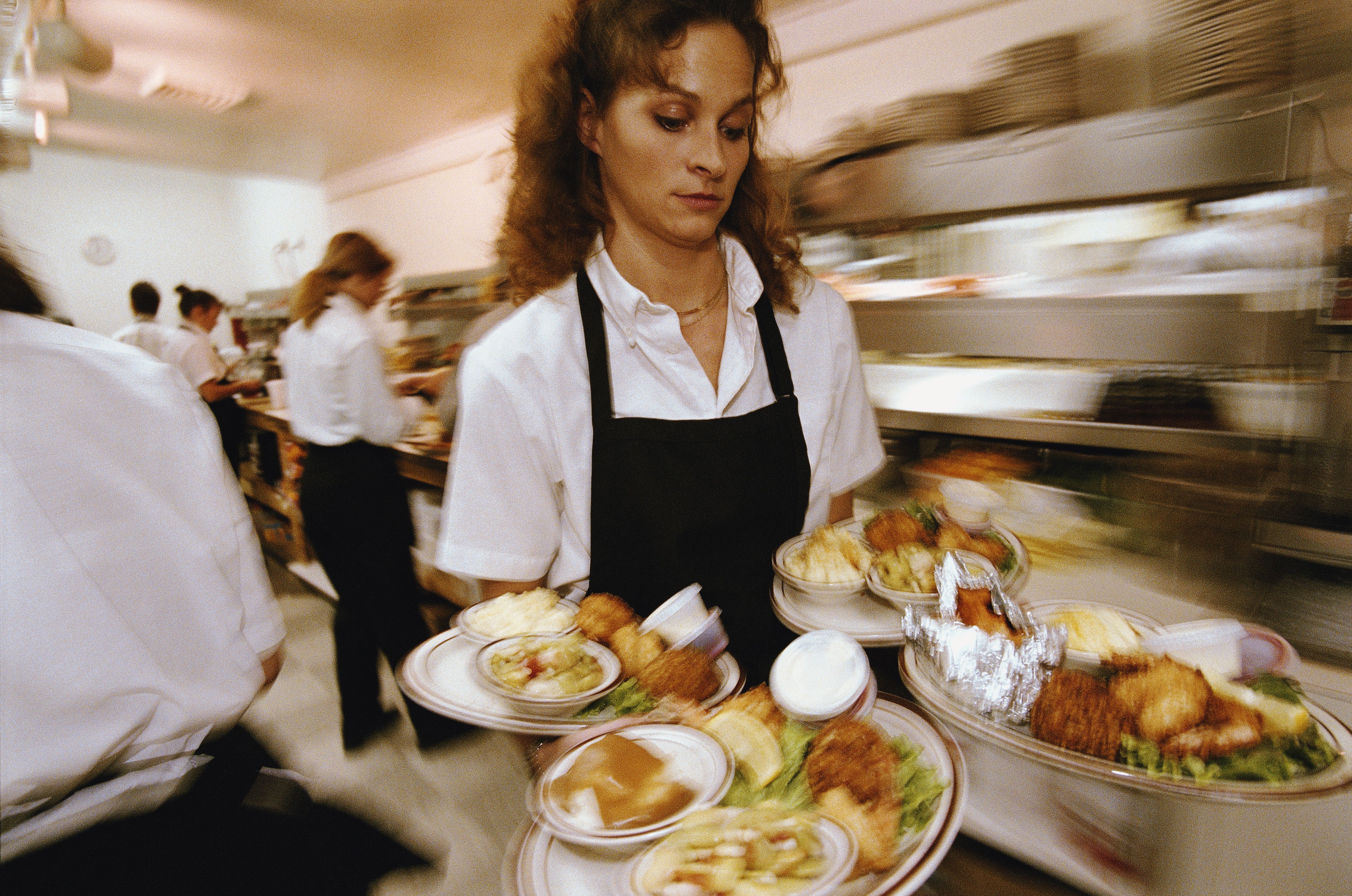 Una cambrera duent plats en un restaurant