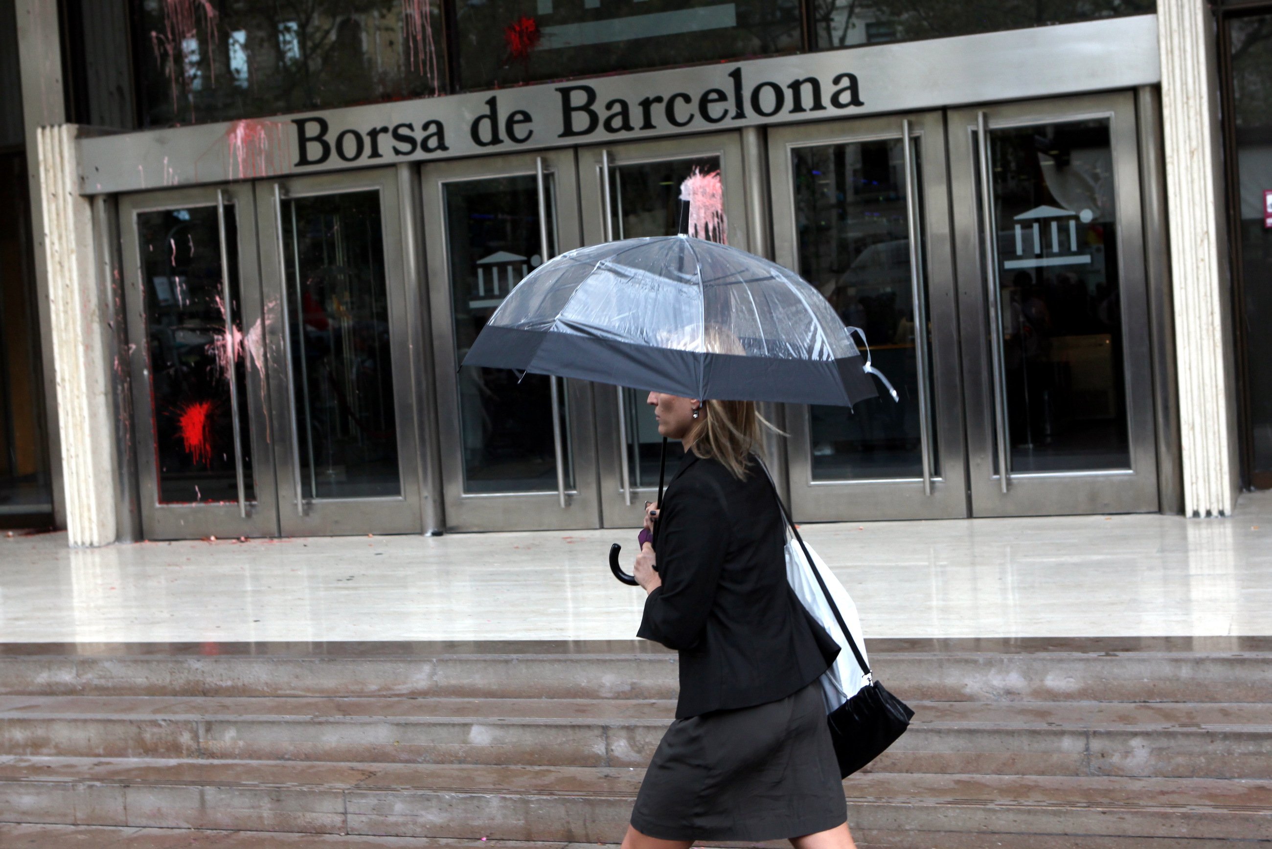 Una dona camina enfront de l'edifici de la Borsa de Barcelona 