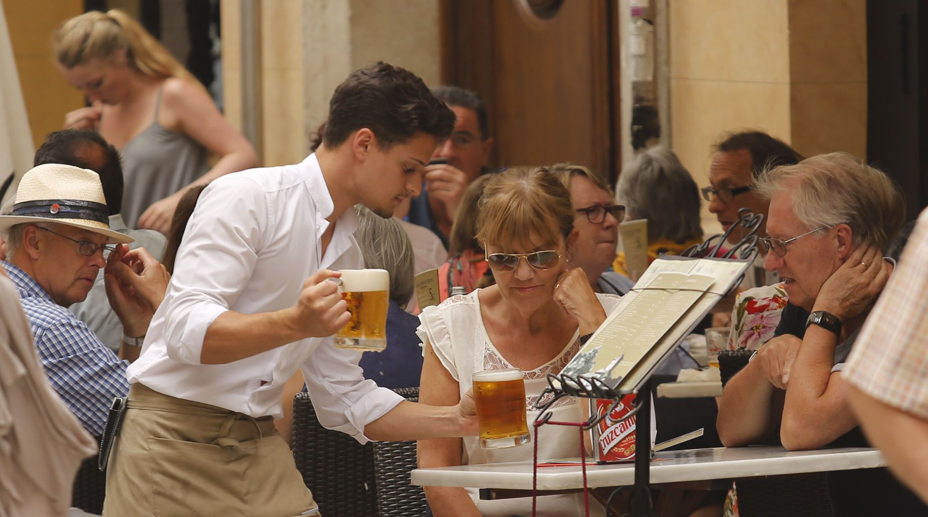 Un cambrer serveix cervesa a Sevilla