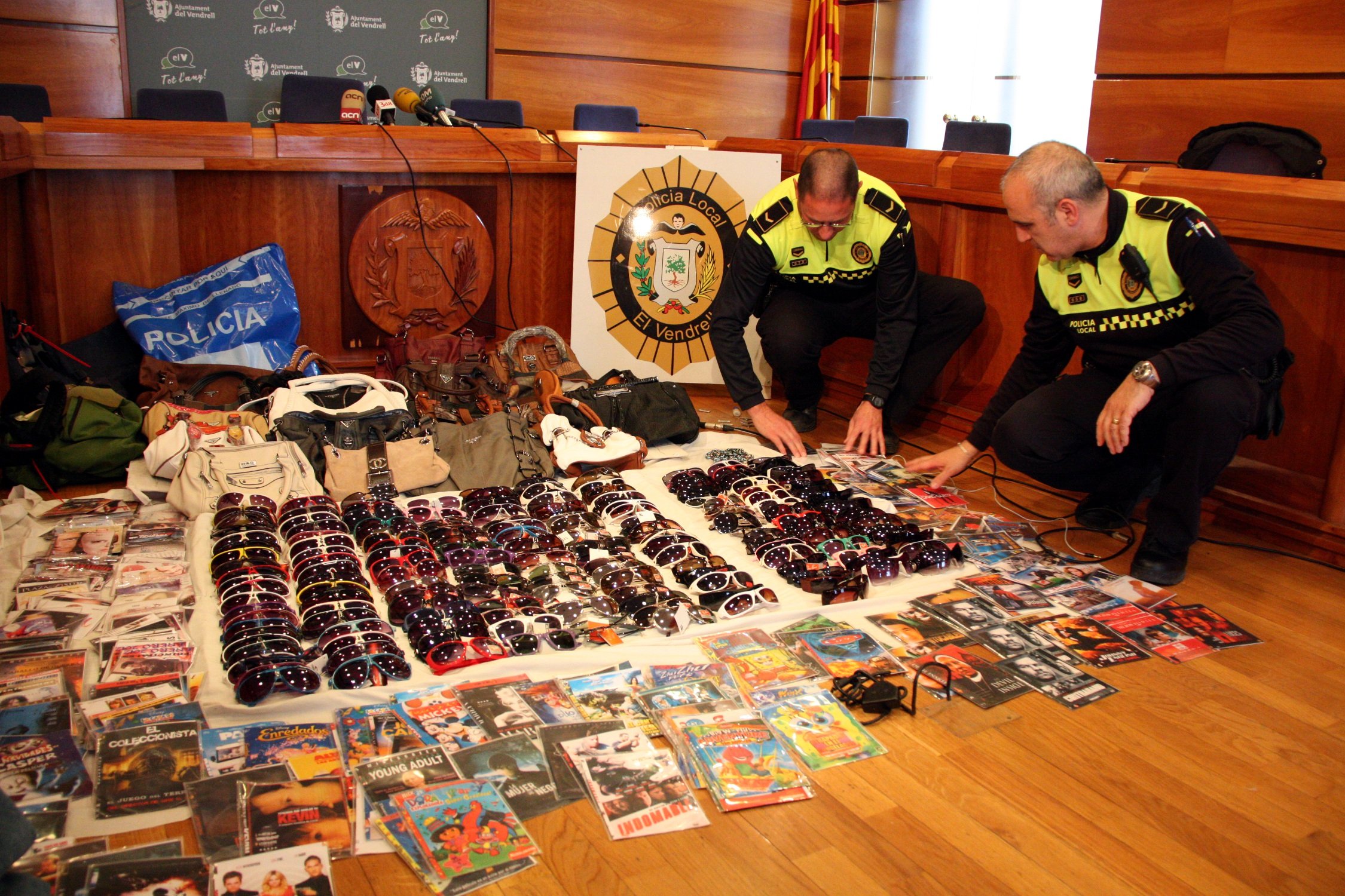 Dos agents de la Policia Local del Vendrell mostren part dels productes il·legals comissats  