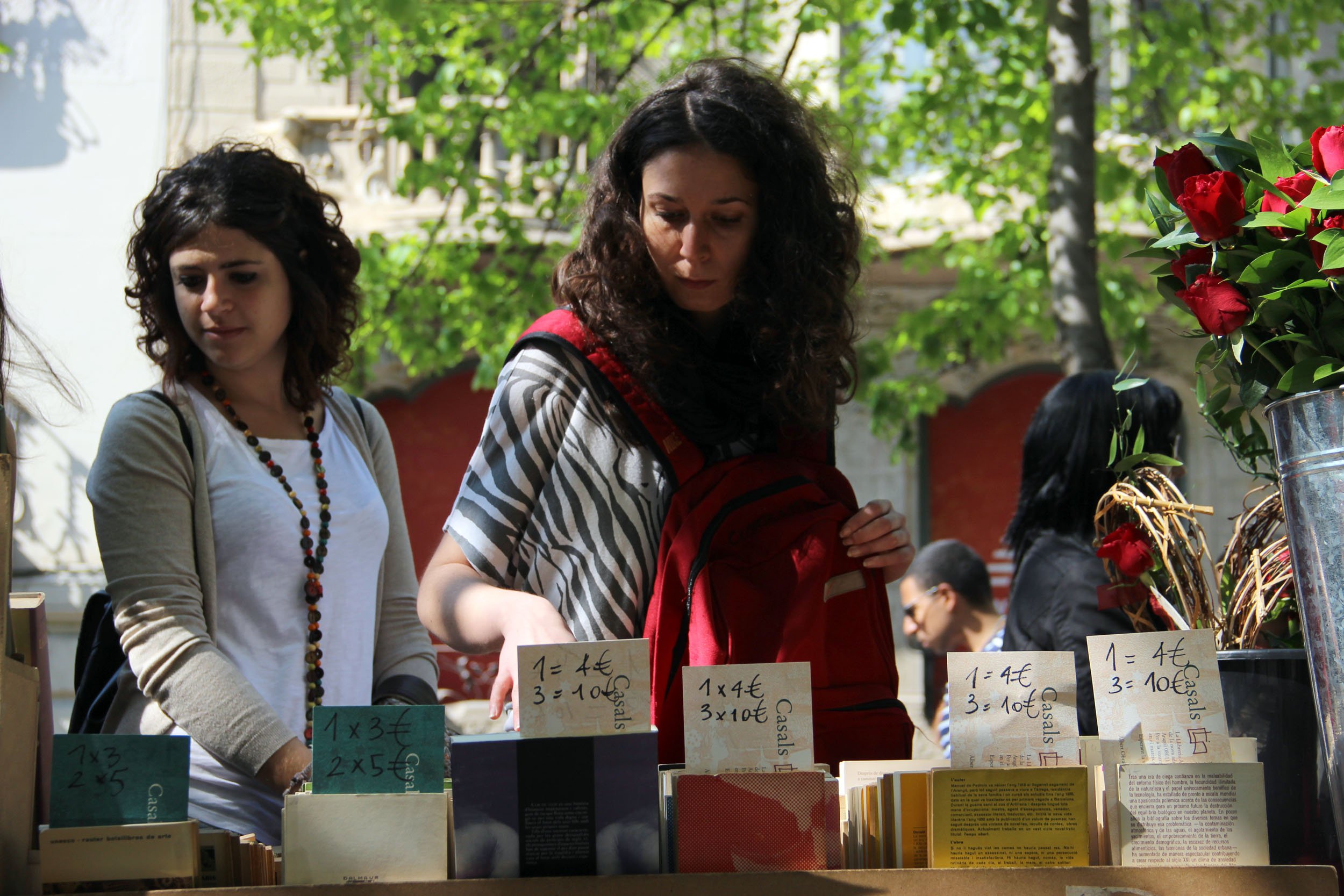 Una dona busca el seu llibre en una de les parades de la Rambla Catalunya 